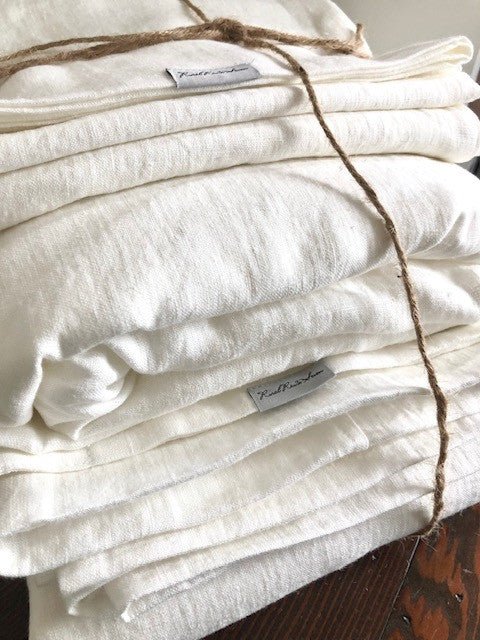 stack of white linen bedding tied with twine