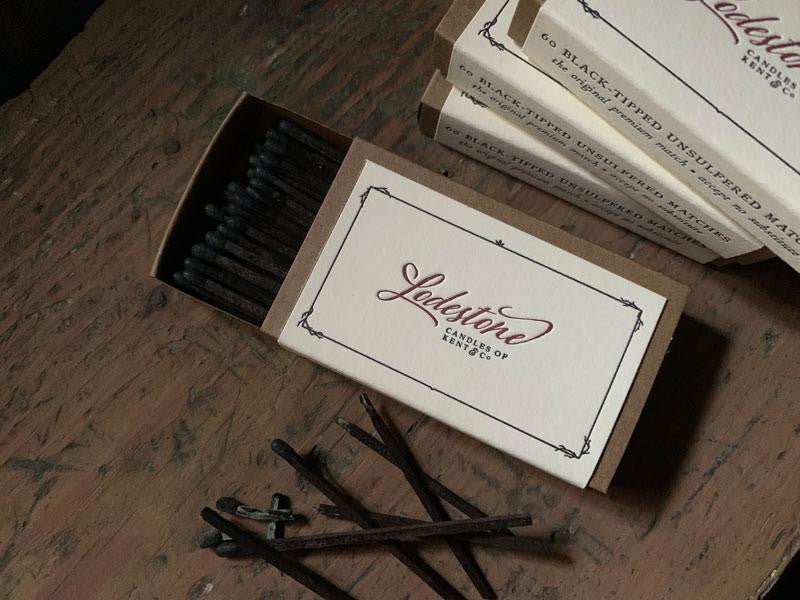 overhead view of extra long Lodestone match box on wood table with spent matches