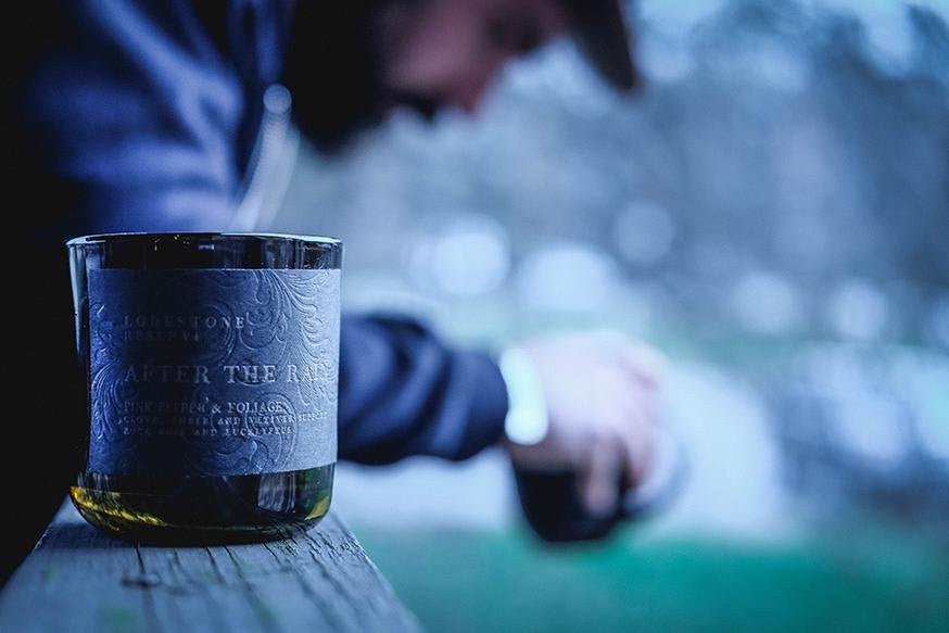 close up of embossed candle label with contemplative man in background