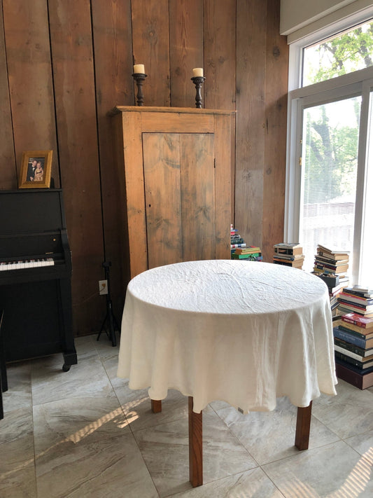 White Stonewashed Linen Tablecloth, 72'' Round on table in sunny room